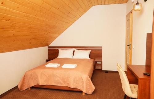 a bedroom with a bed with a wooden ceiling at Urocze Wysowa in Wysowa-Zdrój