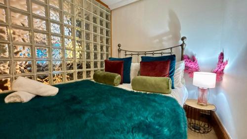 a bedroom with a bed with colorful pillows at Modern Central Large Studio Sleeps 4 in Brighton & Hove