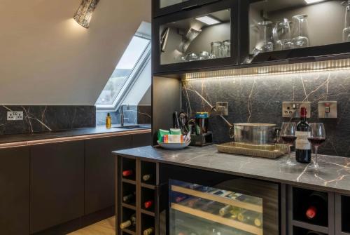 a kitchen with a counter with wine bottles at Arran Shores Luxury Shorefront Penthouse Suite 11 in Lamlash