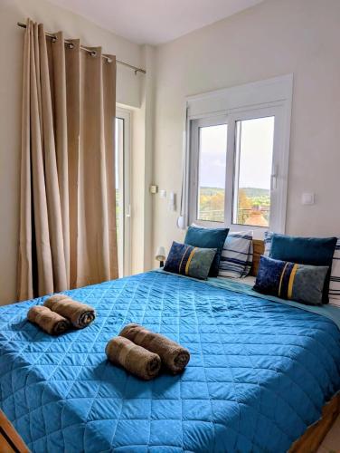 ein großes blaues Bett in einem Schlafzimmer mit Fenster in der Unterkunft Villa Debriz Apartment in Stréfion