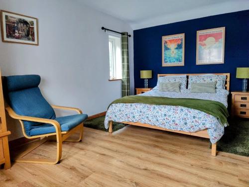 a bedroom with a bed and a chair at Hebron Rural converted chapel in Nantglyn