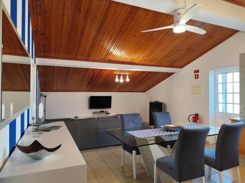a dining room with a table and a ceiling fan at Cantinho a Sul - Costa Nova in Gafanha da Encarnação