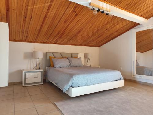a bedroom with a bed and a wooden ceiling at Cantinho a Sul - Costa Nova in Gafanha da Encarnação
