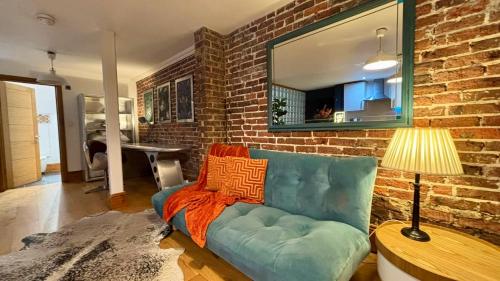 a living room with a blue couch and a brick wall at Modern Central Large Studio Sleeps 4 in Brighton & Hove