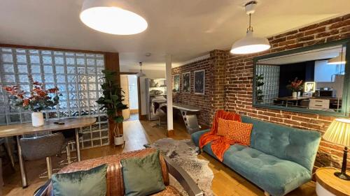 a living room with a couch and a brick wall at Modern Central Large Studio Sleeps 4 in Brighton & Hove