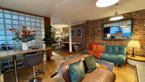 a living room with a couch and a brick wall at Modern Central Large Studio Sleeps 4 in Brighton & Hove