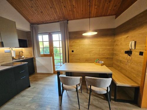 a kitchen with a wooden table and two chairs at Tatralandia Chatka 112 in Liptovský Mikuláš