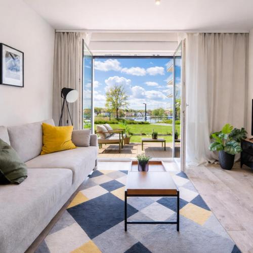 a living room with a couch and a table at ApartView - ogród, taras, winda, widok na Jeziorak, Netflix i Max, parking in Iława