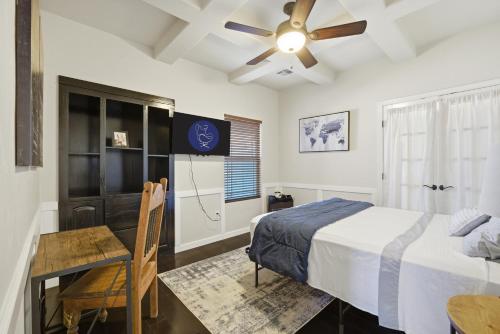 a bedroom with a bed and a table and a ceiling fan at The Palo in Alamogordo