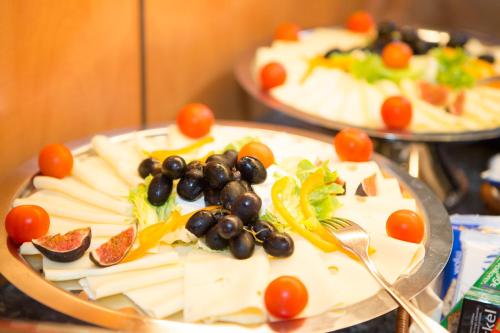 Un plato de comida con uvas y verduras encima. en Hotel Zur Eisenbahn, en Renningen