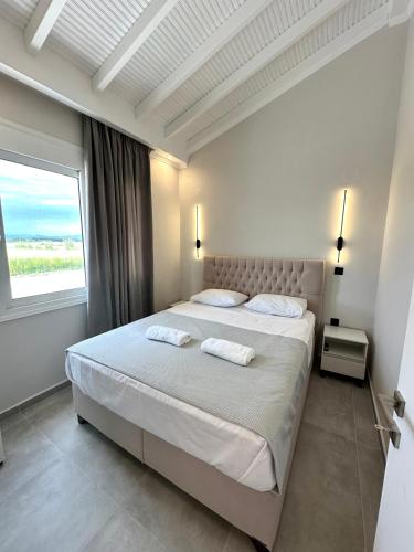 a bedroom with a large bed with a large window at Theros 2 in Xanthi