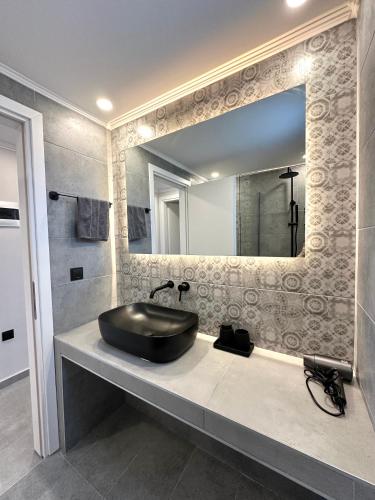 a bathroom with a black sink and a mirror at Theros 2 in Xanthi