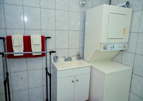 a white bathroom with a sink and a mirror at Cozy one bedroom & Car rental apartment in Lambeau