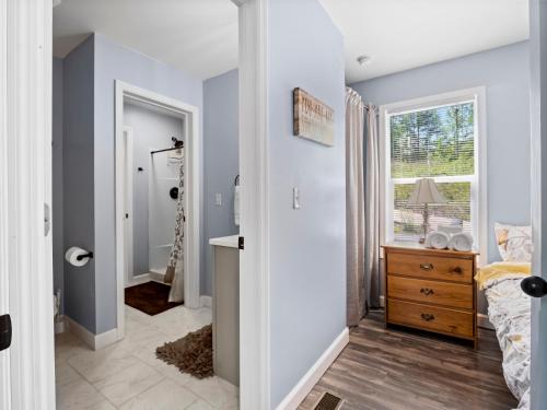 a bedroom with blue walls and a bed and a window at Jax Joint - Pet Friendly - Perfect Family Vacation Spot! in Crane Hill