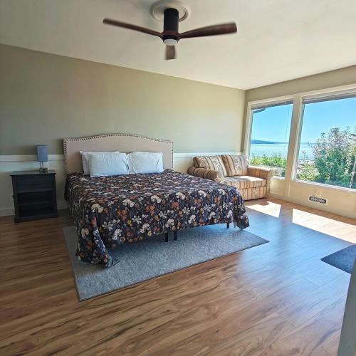 a bedroom with a bed and a ceiling fan at Saltwater Beach Home with Ocean View in Des Moines