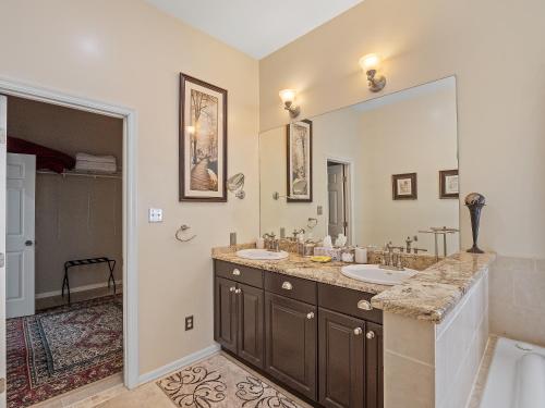 a bathroom with two sinks and a large mirror at Rocking W - Screened In Porch And Lakeside Fire Pit! in Double Springs
