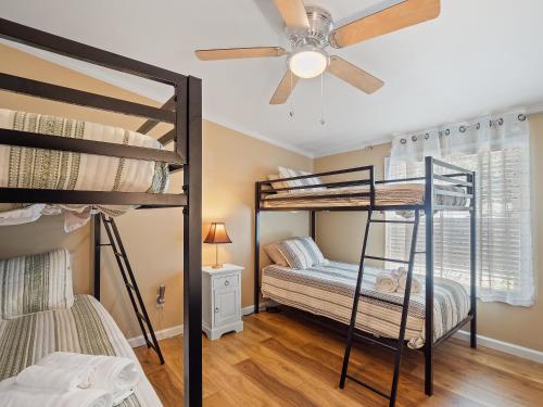 a bedroom with two bunk beds and a ceiling fan at Rocking W - Screened In Porch And Lakeside Fire Pit! in Double Springs