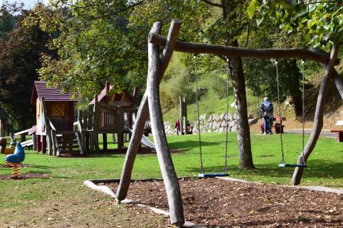 a park with a playground with a swing at Apart Erica in Comano Terme
