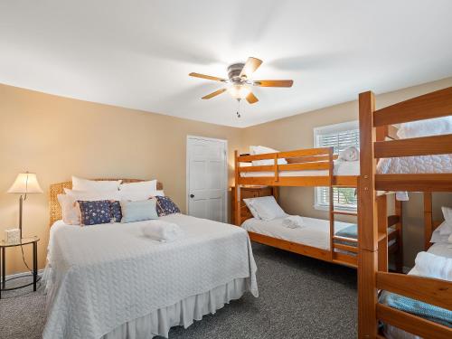 a bedroom with two bunk beds and a ceiling fan at Carols Cottage - Double Decker Dock! Popular Location! in Cullman