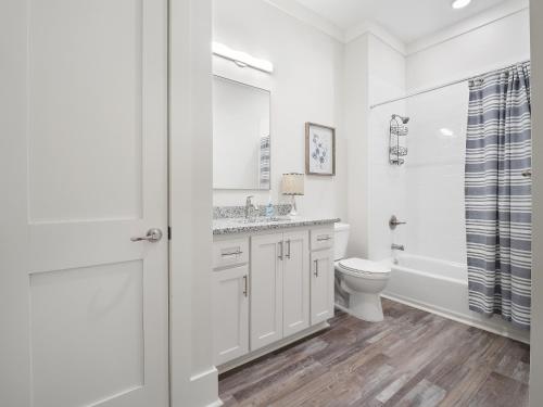 a white bathroom with a toilet and a sink at Mallard Pointe 100 - Luxury Condo- Conveniently Located! in Cullman