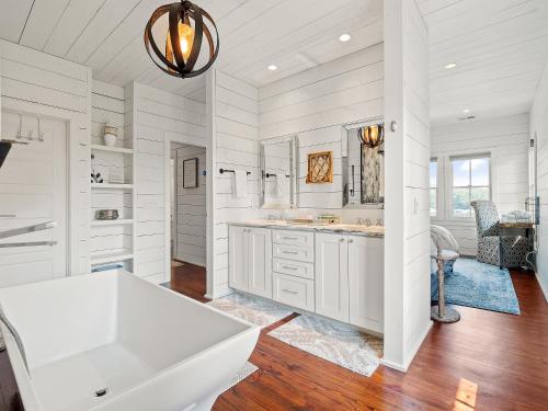 a white bathroom with a sink and a tub at Central Perk - Pet Friendly, Luxury Cabin Feel, Kayaksand Coffee! in Crane Hill