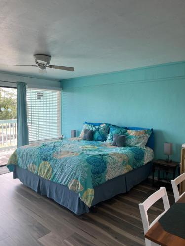 a bedroom with a bed and a blue wall at Park Place Condo 227 in Cedar Key
