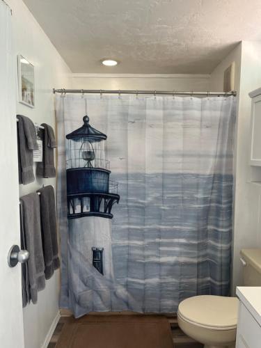 a bathroom with a shower curtain with a lighthouse at Park Place Condo 227 in Cedar Key