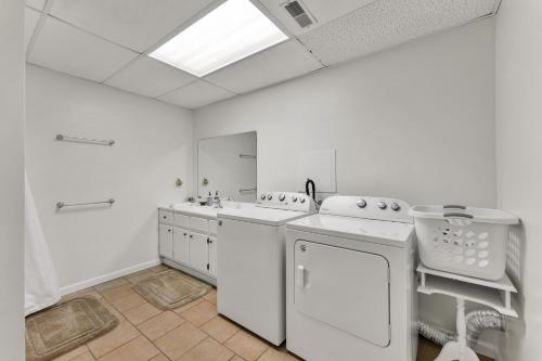 a white kitchen with a sink and a dishwasher at Blessings Family Lodge- Amazing Sunsets, Amazing Views! in Houston