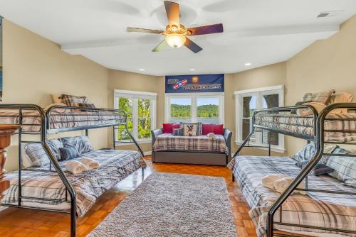 a room with three bunk beds and a ceiling fan at Lake Therapy - Gazebo On The Lake, Easy Walk To The Water! in Crane Hill
