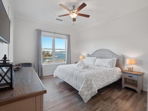 a bedroom with a bed with a ceiling fan and a window at Mallard Pointe 100 - Luxury Condo- Conveniently Located! in Cullman