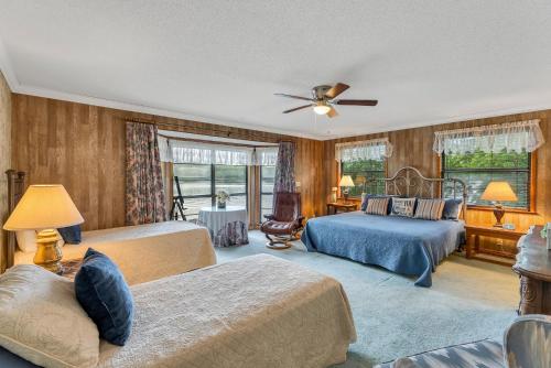 a bedroom with two beds and a ceiling fan at Nanas Lakehouse - Private Dock With Jet-Ski Port! in Jasper