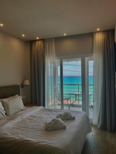 a bedroom with a bed with a view of the ocean at Horizon in Pefkochori