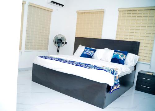 a bedroom with a black bed with blue pillows at Riverside Nest Owerri Ltd in Owerri