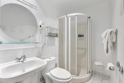 a bathroom with a toilet and a sink and a shower at Hotel Charles-Alexandre - Par Aneyro in Quebec City