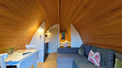 a living room with a large wooden ceiling and a couch at Glamping at Honnington Farm in Royal Tunbridge Wells