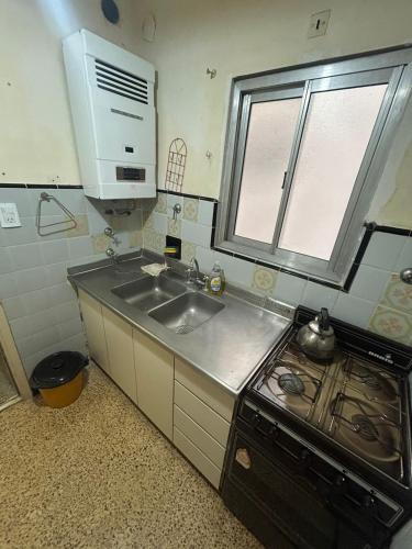 a small kitchen with a sink and a stove at Monoambiente a 100 m del mar in Necochea