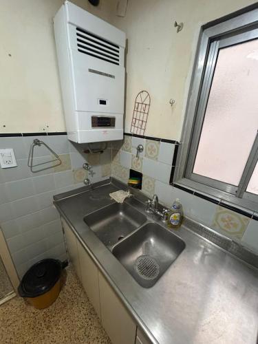 a kitchen with a stainless steel sink and a window at Monoambiente a 100 m del mar in Necochea