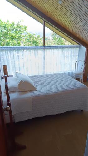 a bedroom with a white bed and a window at Mindo Suites - Toucans in Quito