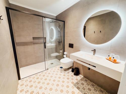 a bathroom with a shower and a sink and a toilet at Vila Channa - Adults Only in Albufeira