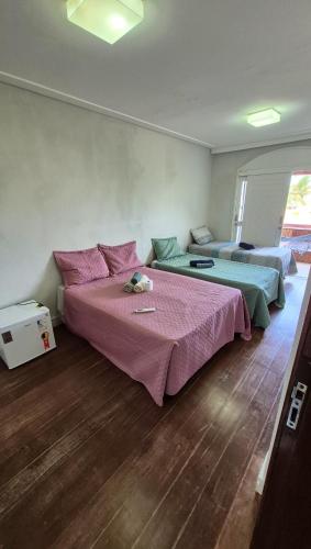 a bedroom with two beds with pink and green sheets at Pitaia 3 in Aracaju