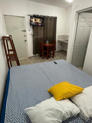 a bedroom with a bed with a yellow pillow on it at Hotel AF2 in Tizimín