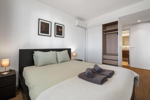 a bedroom with a large bed with two towels on it at Oceanfront Bliss - Atlantico residences in Câmara de Lobos