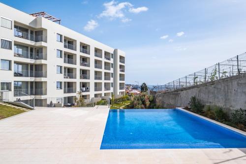 an empty swimming pool in front of a building at Oceanfront Bliss - Atlantico residences in Câmara de Lobos