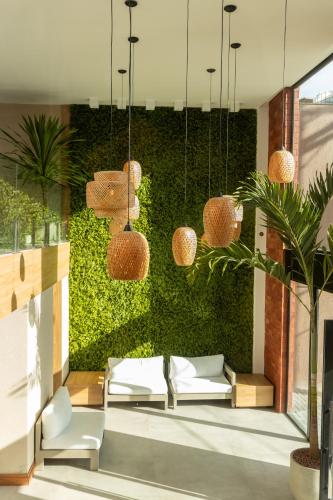 a lobby with chairs and a green wall at Sereno Hotel in Cabo Frio