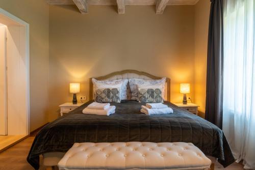 a bedroom with a large bed with two lamps at Őri Art Inn in Őriszentpéter