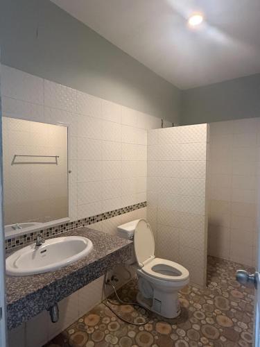 a bathroom with a toilet and a sink at Safary Tour in Ban Ta Kun