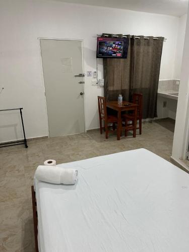 a room with a bed and a table and a television at Hotel AF 14 in Tizimín