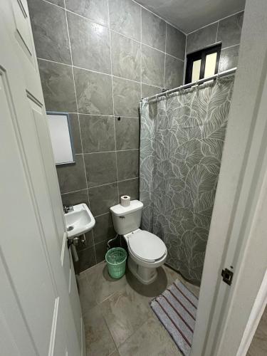 a small bathroom with a toilet and a sink at Hotel AF 14 in Tizimín