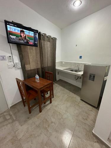 a small room with a table and a tv on the wall at Hotel AF 14 in Tizimín