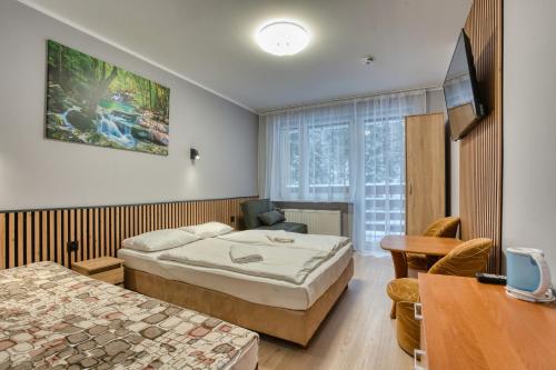 a hotel room with two beds and a table at Willa Świerkowa in Karpacz